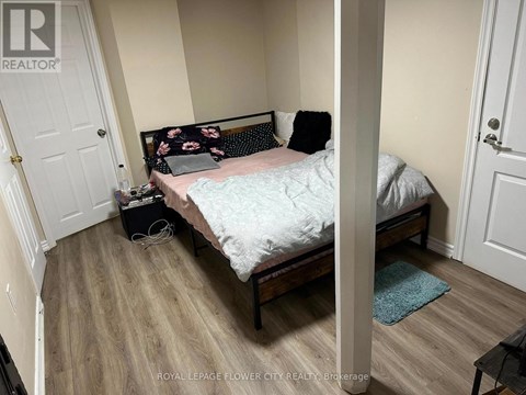 A bedroom with a bed, pillows, and a laptop on the bed.