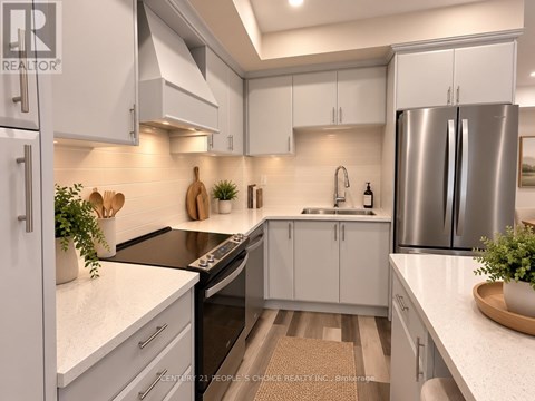 A modern kitchen with white cabinets and stainless steel appliances.