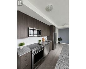 A modern kitchen with dark wood cabinets and stainless steel appliances.