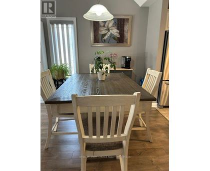 A dining room with a wooden table and chairs.