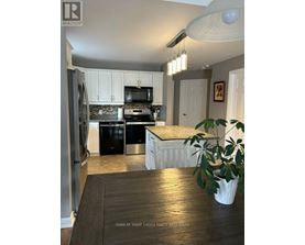 A kitchen with a refrigerator, stove, and oven.