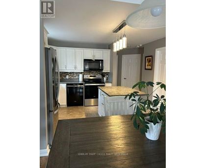 A kitchen with a refrigerator, stove, and oven.
