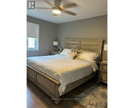A bedroom with a large bed and a ceiling fan.