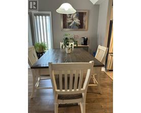A dining room with a wooden table and chairs.