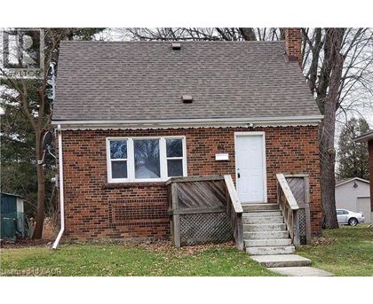 A small brick house with a white door and a small porch.