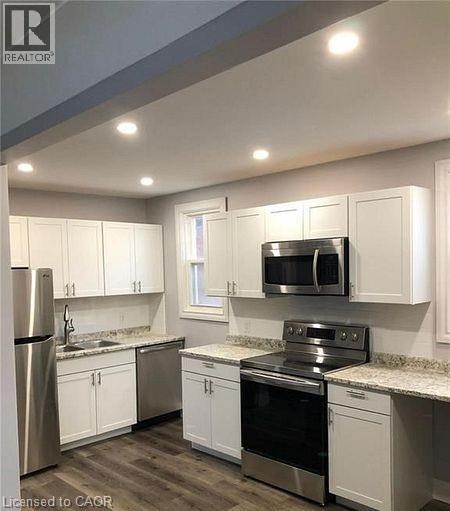 A kitchen with white cabinets and stainless steel appliances.