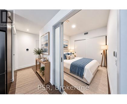 A bedroom with a bed, nightstand, and a small table with a plant on it.