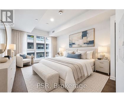 A bedroom with a large bed, a couch, and a painting on the wall.