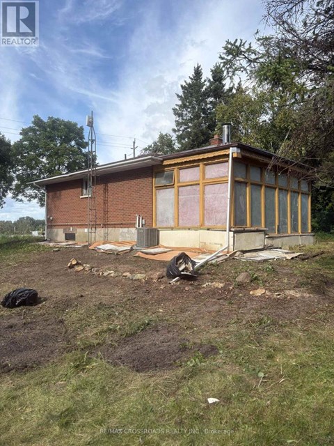 A house under construction with a brown roof and yellow framing.