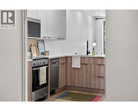 A modern kitchen with wooden cabinets and a stainless steel oven.