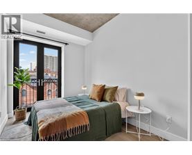 A bedroom with a large bed and a balcony with a view of a building.