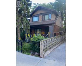 A house with a black fence and a brown roof.