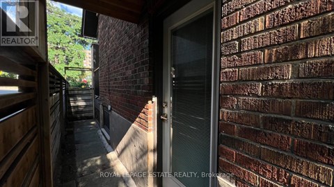 A brick wall with a door and a sign that says REALTOR.