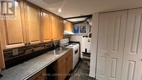 A kitchen with wooden cabinets and a stainless steel sink.
