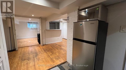 A kitchen area with a stainless steel refrigerator and a microwave oven.