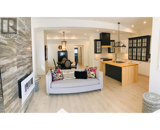 A modern living room with a grey sofa and a stone wall.