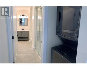 A modern kitchen with a stainless steel oven and a sink with a mirror above it.