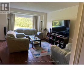 A living room with a couch, chair, and television.