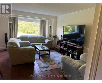 A living room with a couch, chair, and television.