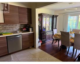 A kitchen with wooden cabinets and a dining table with chairs.