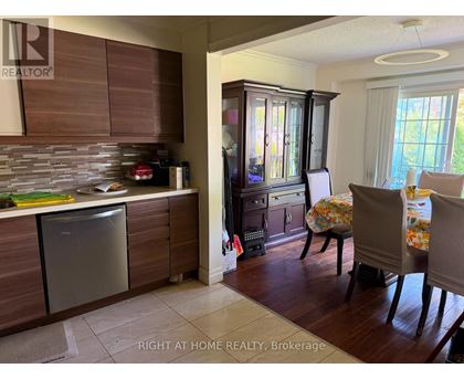 A kitchen with wooden cabinets and a dining table with chairs.