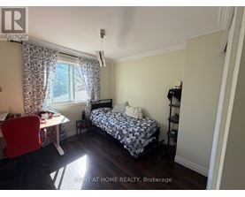 A bedroom with a bed, desk, and chair.