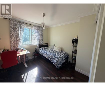 A bedroom with a bed, desk, and chair.
