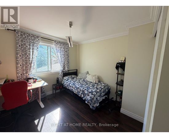 A bedroom with a bed, desk, and chair.