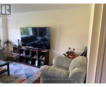 A living room with a television and a grey couch.
