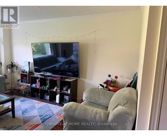 A living room with a television and a grey couch.