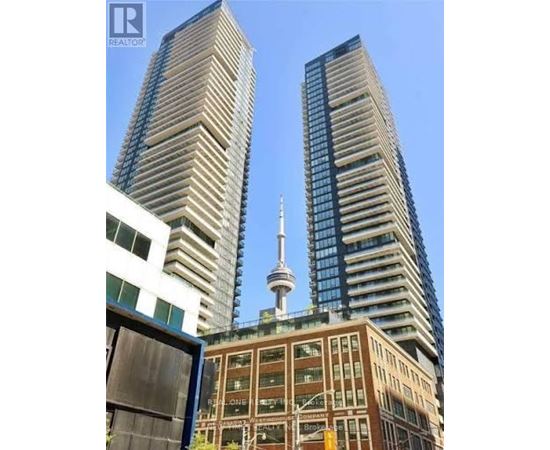 Two tall buildings with a tower in the background.