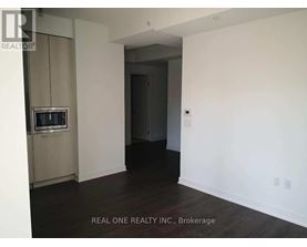 A room with a television and a doorway leading to another room.
