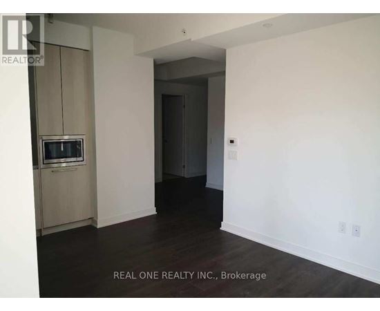 A room with a television and a doorway leading to another room.