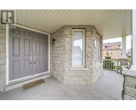 A grey door with a glass window is on a stone wall.