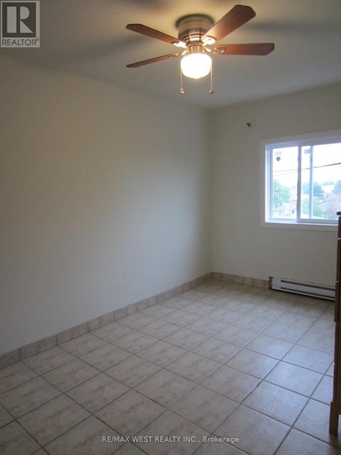 A room with a ceiling fan and a window.