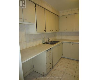 A kitchen with white cabinets and a sink.