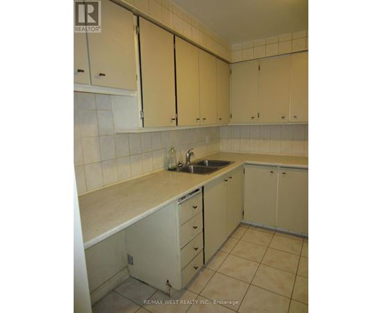 A kitchen with white cabinets and a sink.