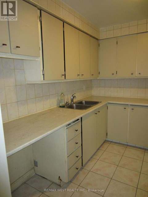 A kitchen with white cabinets and a sink.