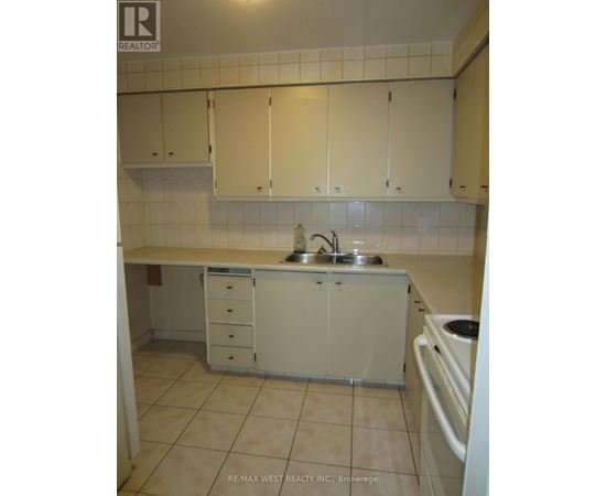 A kitchen with white cabinets and a sink.