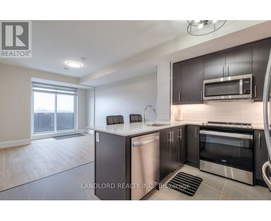 A modern kitchen with dark brown cabinets and stainless steel appliances.