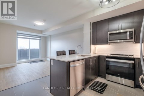 A modern kitchen with dark brown cabinets and stainless steel appliances.