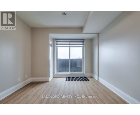 A room with a window and a door leading to a balcony.
