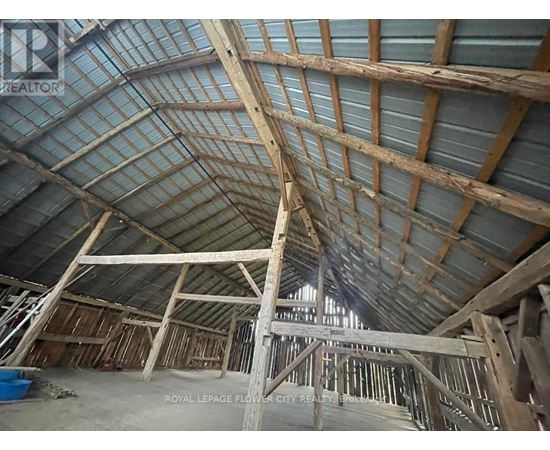 A large unfinished building with wooden beams and a glass roof.