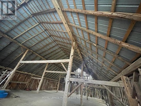 A large unfinished building with wooden beams and a glass roof.