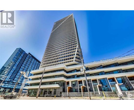 A tall building with a glass facade stands in front of a smaller building with a metal facade.