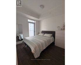 A bedroom with a large bed and a window.
