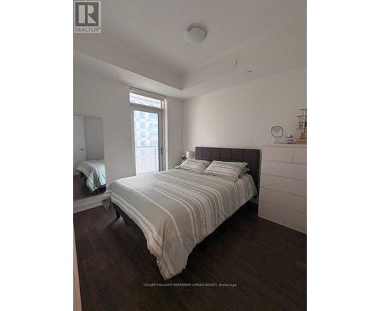 A bedroom with a large bed and a window.