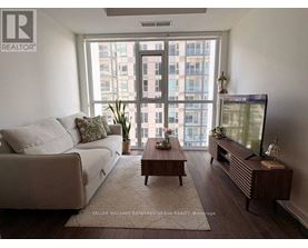 A living room with a couch, a coffee table, and a television.