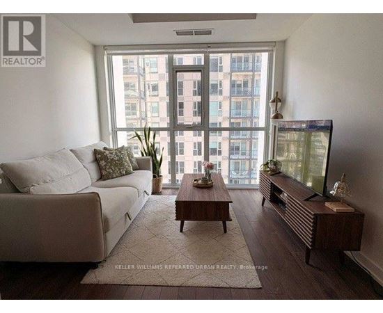A living room with a couch, a coffee table, and a television.