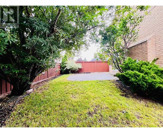 A red gate leads to a building surrounded by greenery.